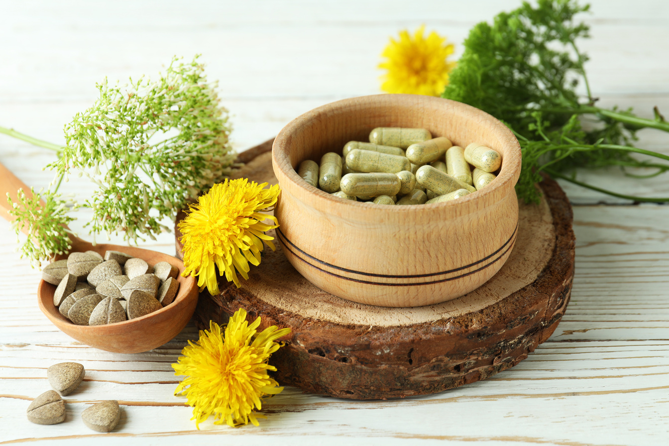 Concept of Herbal Medicine Pills on White Wooden Table, Close up